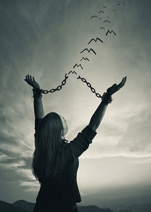 concept image of young woman breaking free of chains and the broken links are flying away like birds - Springfield, IL