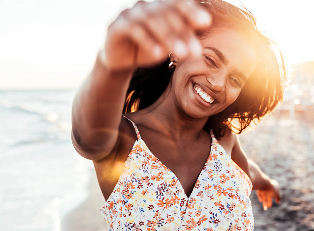 woman running freely on a beach